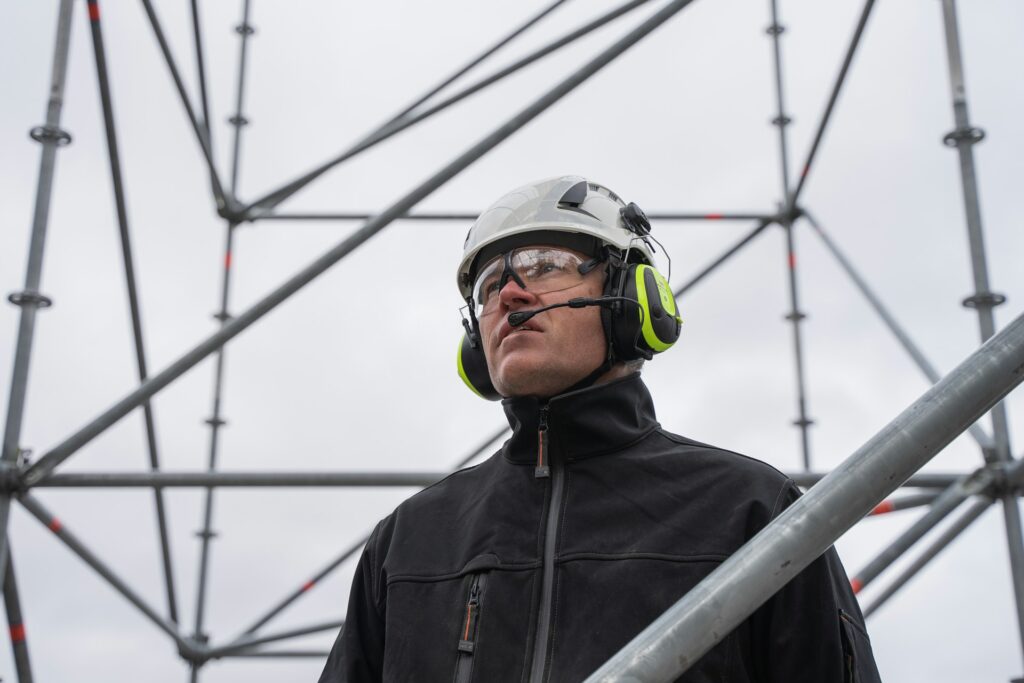 Un homme avec un casque de chantier anti-bruit sur une passerelle
